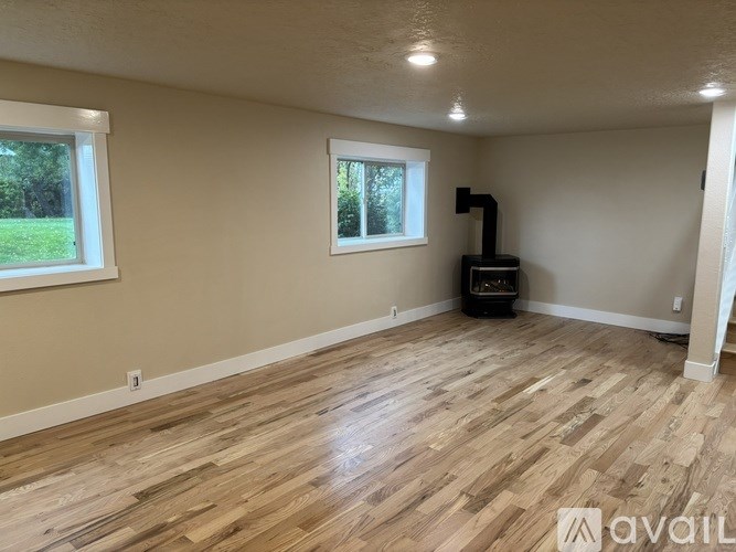 A room with wooden flooring and a window.