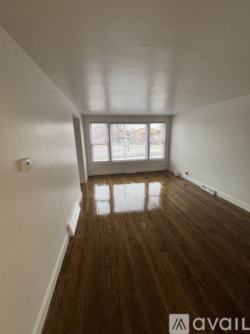 A room with wooden flooring and white walls.