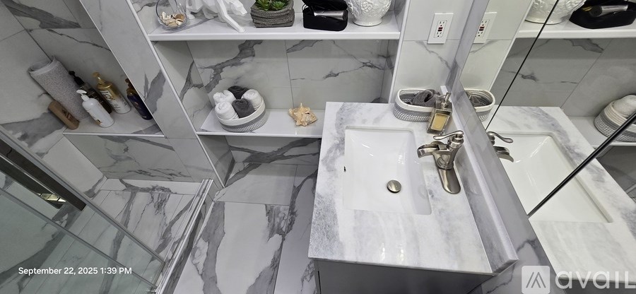 A bathroom with a marble sink and a mirror.