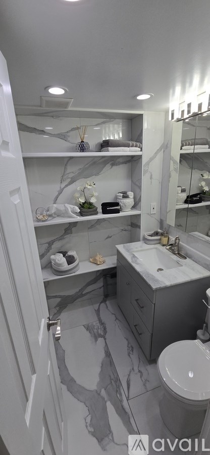 A bathroom with a marble floor and white walls.