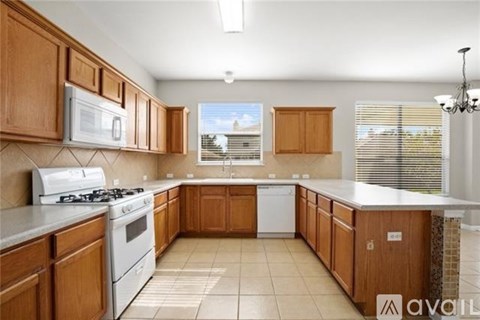 A kitchen with wooden cabinets and white appliances.