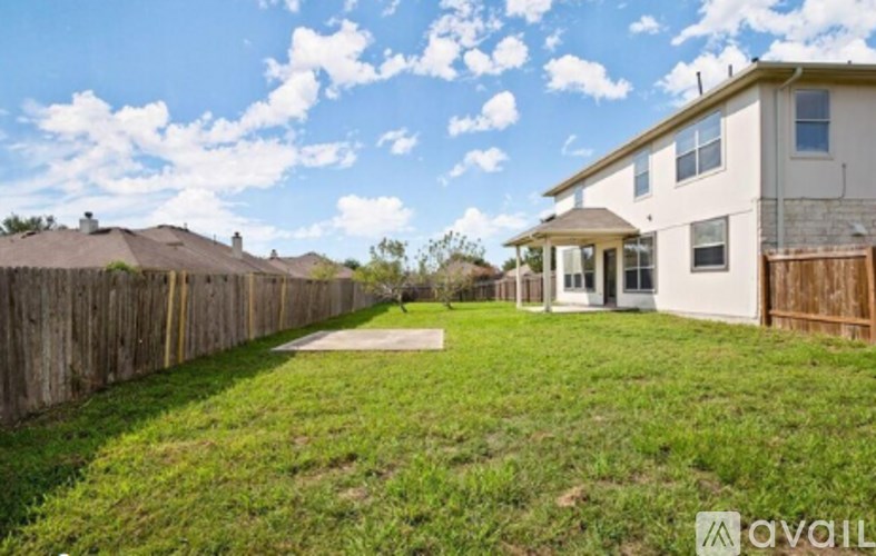 A house with a fence and a clear sky in the background.