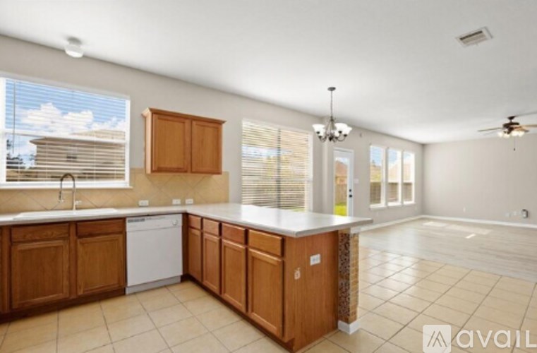 A kitchen with wooden cabinets and a white dishwasher.