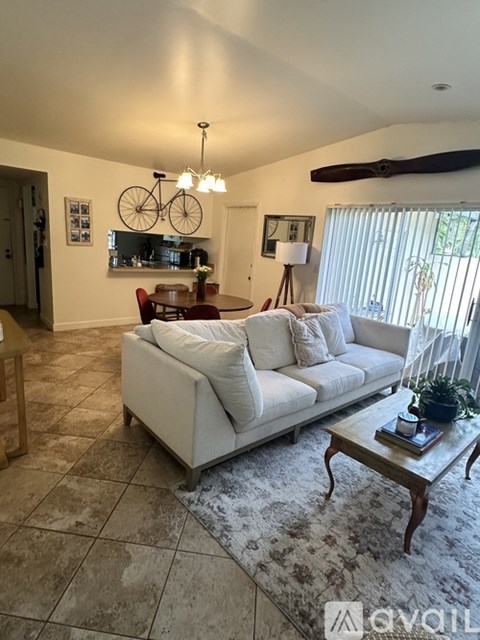 A living room with a white couch and a coffee table.