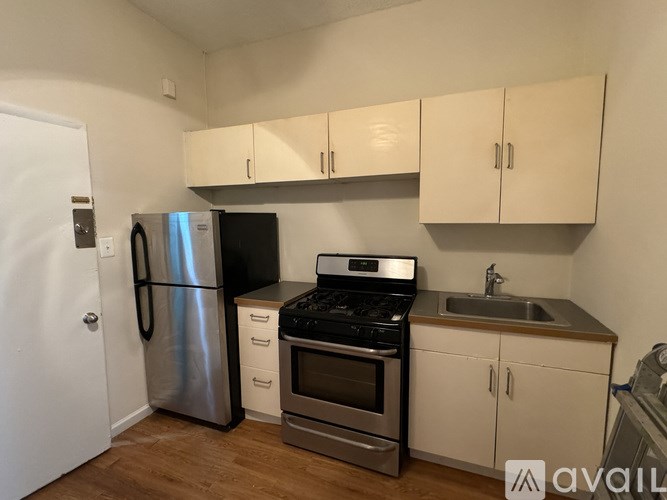A kitchen with a stainless steel refrigerator, oven, and cabinets.
