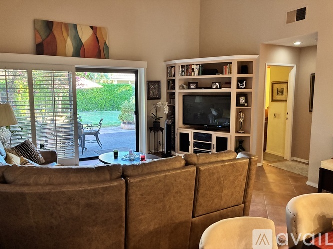 A living room with a brown couch and a television.