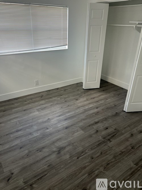 A room with a wooden floor and a white door.