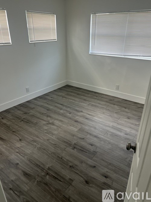 A room with wooden flooring and a white door.