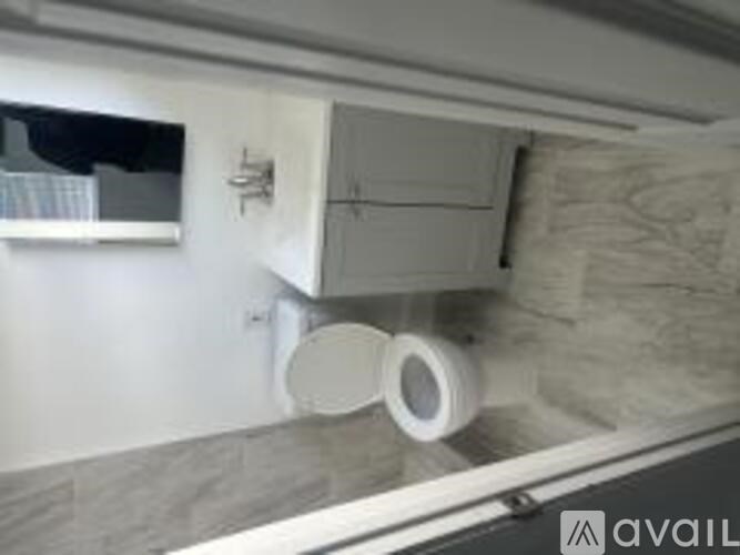 A white toilet is installed in a room with a grey floor.