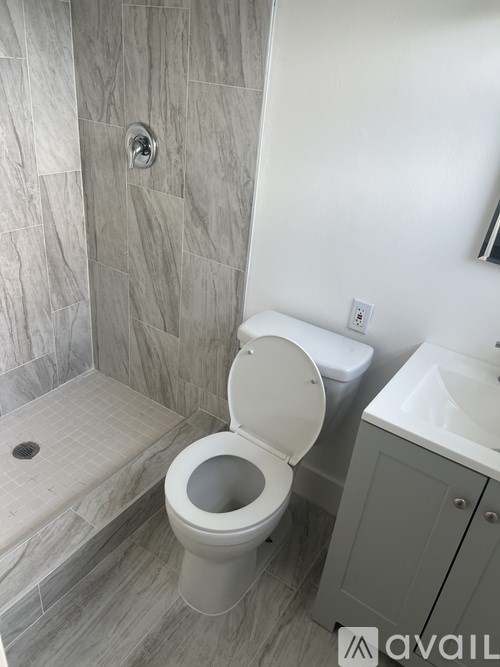 A toilet with a toilet paper holder on the wall.