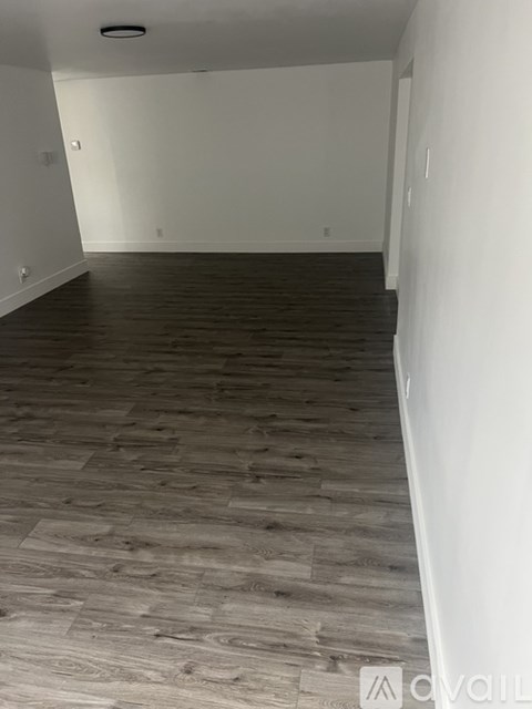 A room with wooden flooring and white walls.
