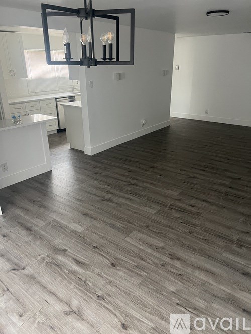 A room with wooden flooring and a large mirror on the wall.