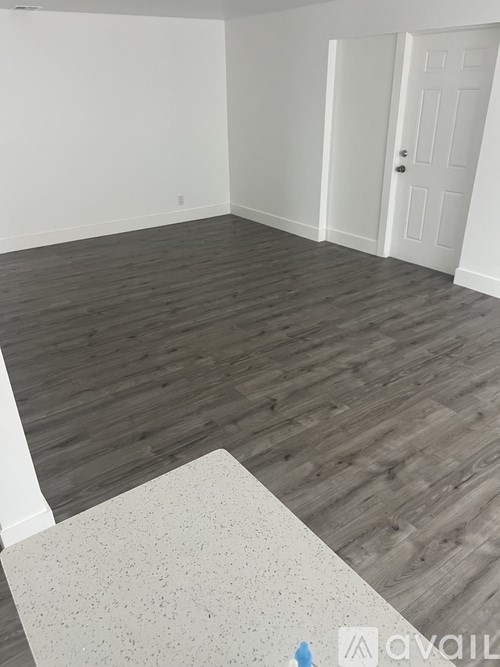 A room with wooden flooring and a white door.