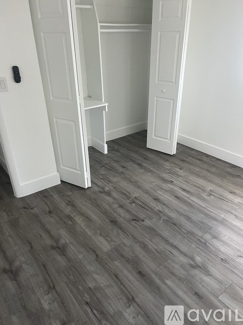 A room with a white door and a wooden floor.