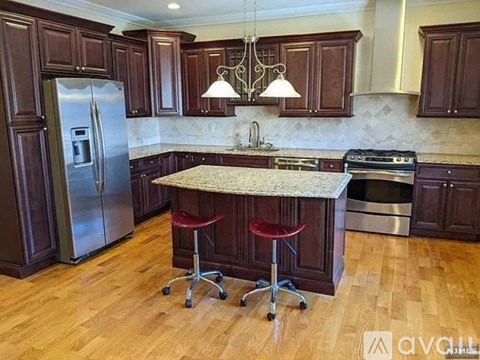 A kitchen with wooden cabinets and a marble countertop.