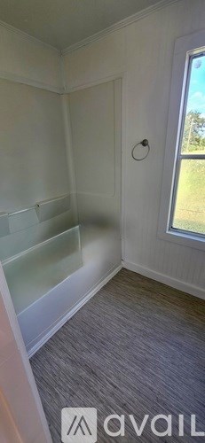 A room with a window and a carpeted floor.