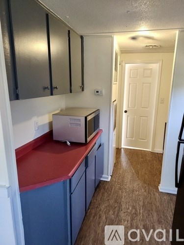 A room with a chandelier and a window with blinds.