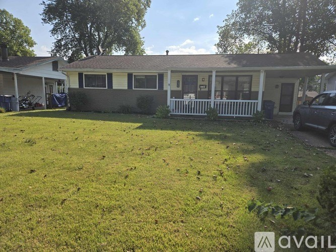 A house with a white picket fence and a car parked in the driveway.