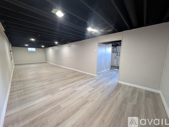A room with a white door and wooden flooring.