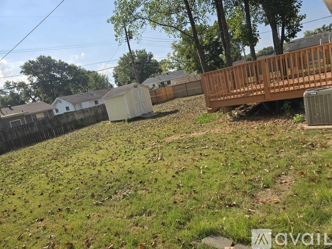 A backyard with a wooden deck and a grassy area.