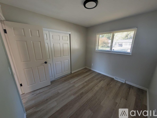 A room with a wooden floor and a window.