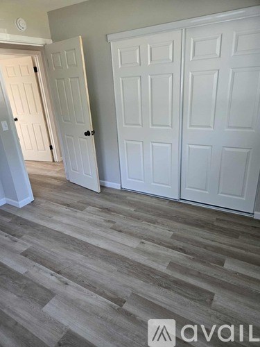 A room with white doors and a wooden floor.