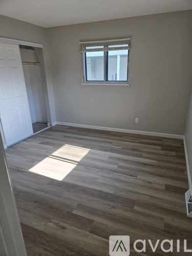 A room with wooden flooring and a window.
