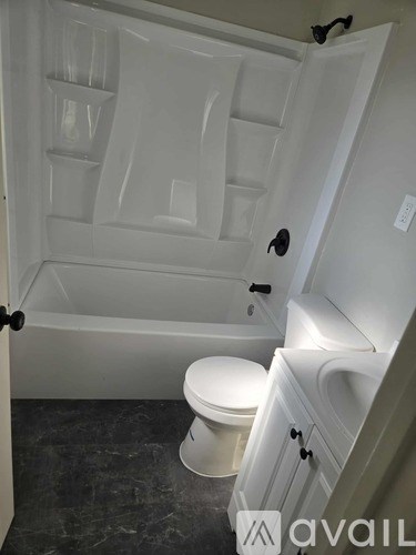 A white bathroom with a toilet and a bathtub.