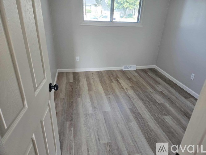 A room with a wooden floor and a door.