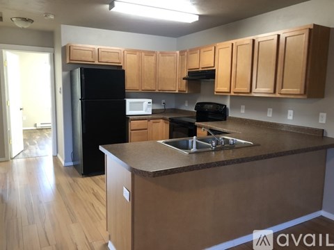 A kitchen with wooden cabinets and black appliances.
