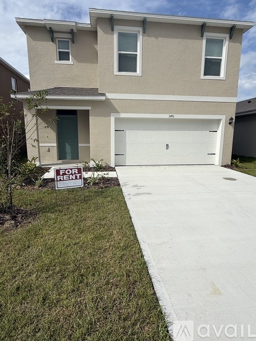 A beige house with a garage door is for rent.