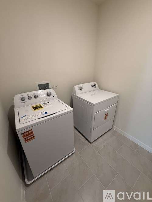 Two white washing machines in a small room.