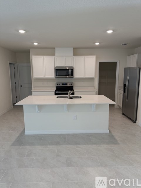 A kitchen with white cabinets and a central island.