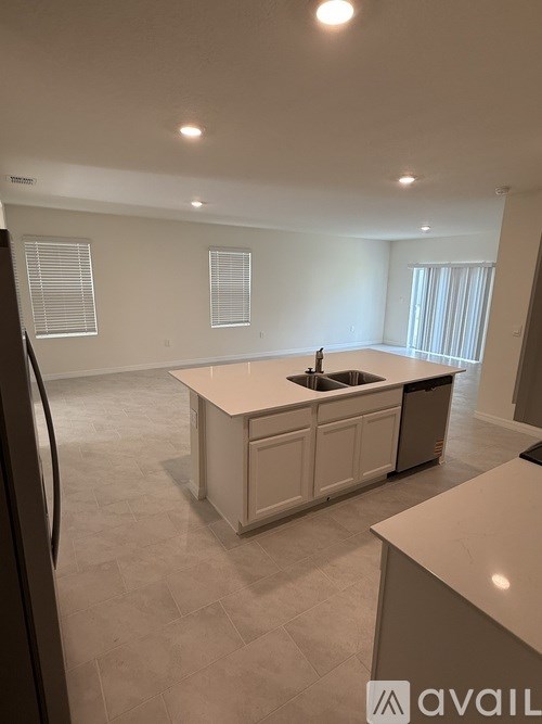 A kitchen with a sink and a refrigerator.