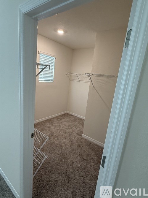A room with a carpeted floor and a window with blinds.