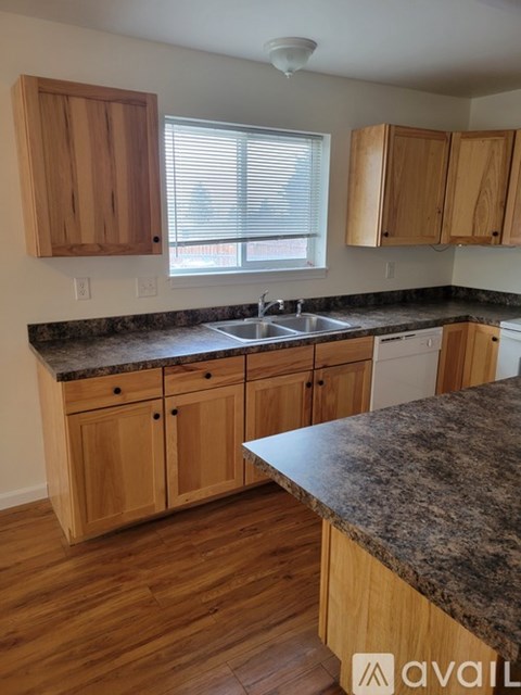 A kitchen with wooden cabinets and granite countertops.