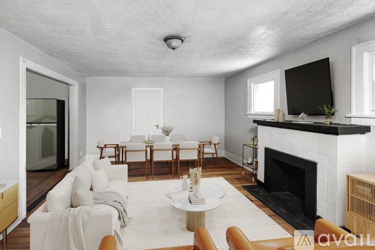 A living room with a fireplace and a television on the wall.