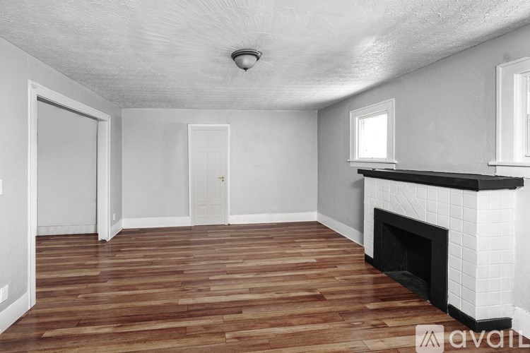 A room with a fireplace and wooden floors.