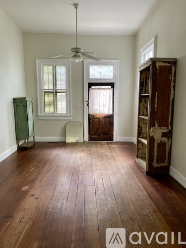 A room with wooden floors and a ceiling fan.