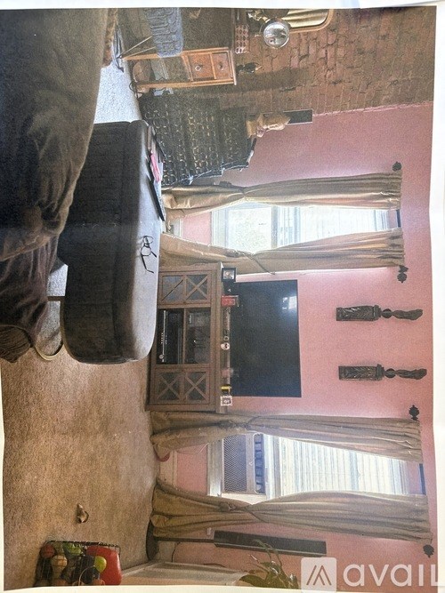 A room with a television and a person's leg hanging off the side.