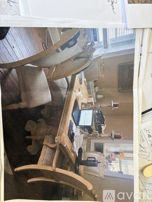 A wooden rocking horse with a black seat and a white saddle.