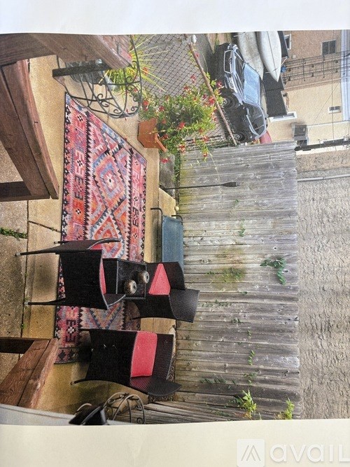 A red and black patterned rug hangs on a wall.