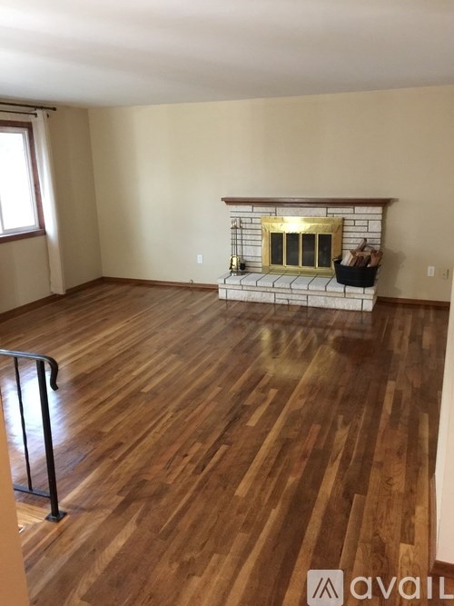 A room with wooden floors and a fireplace.
