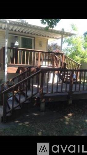 A wooden deck with a railing and a bench.