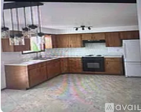 A kitchen with wooden cabinets and a white fridge.