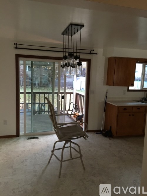 A room with a chair and a hanging light fixture.