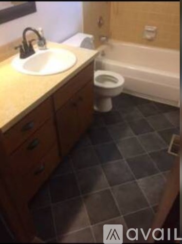 A bathroom with a toilet, sink, and bathtub.