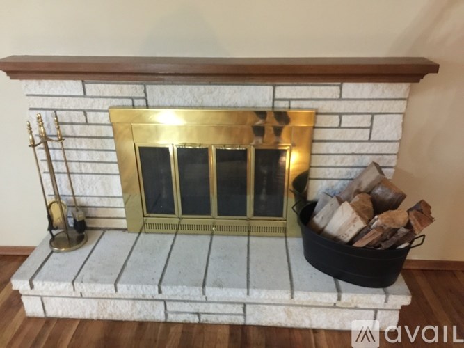 A fireplace with a firewood bucket on the right side.