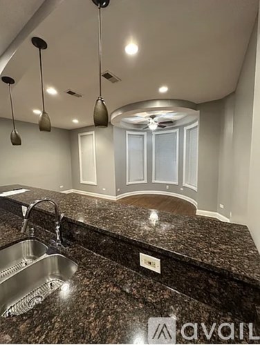 A kitchen with granite countertops and a stainless steel sink.