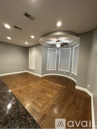 A room with wooden flooring and a ceiling fan.